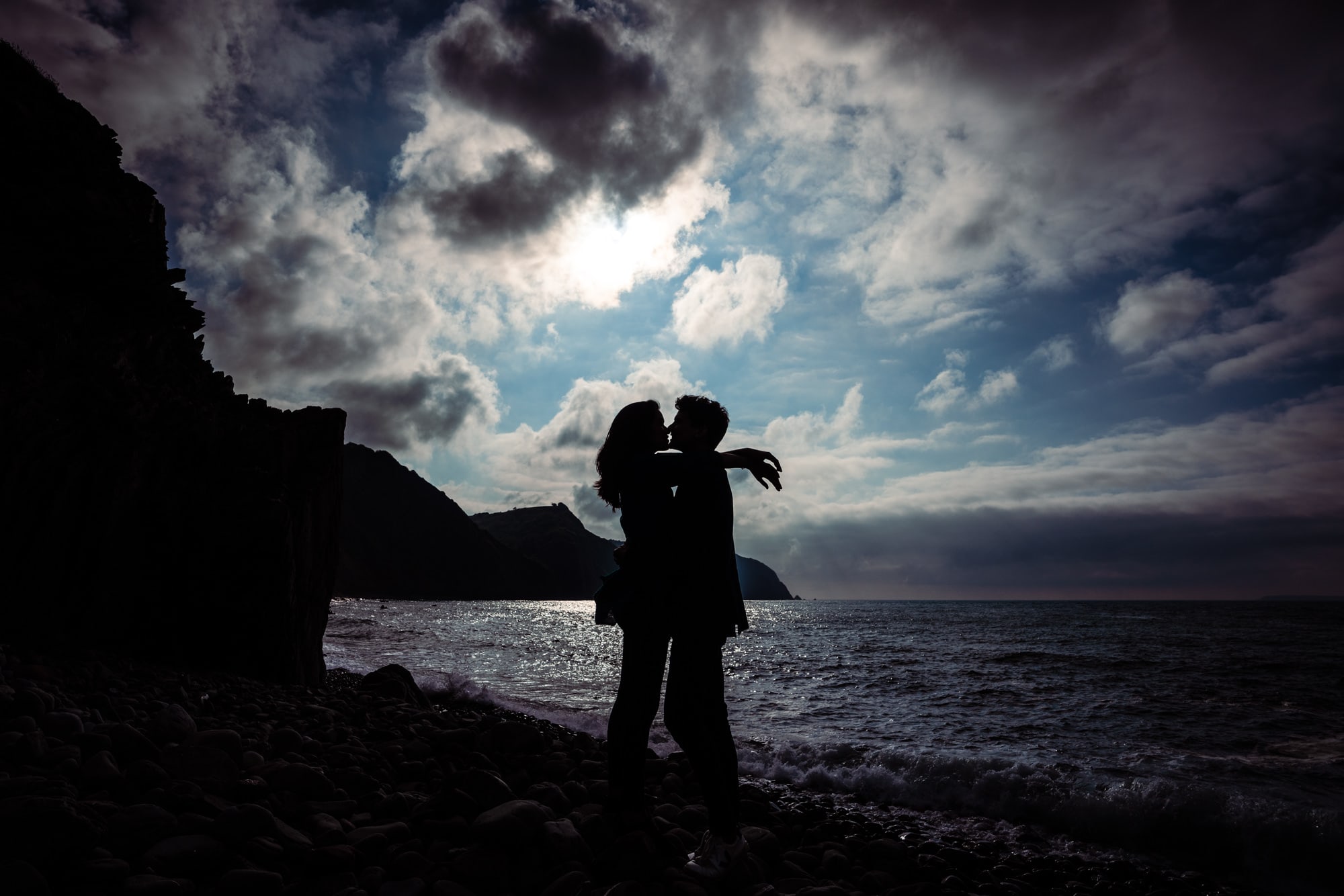 silhouette of couple kissing on coast