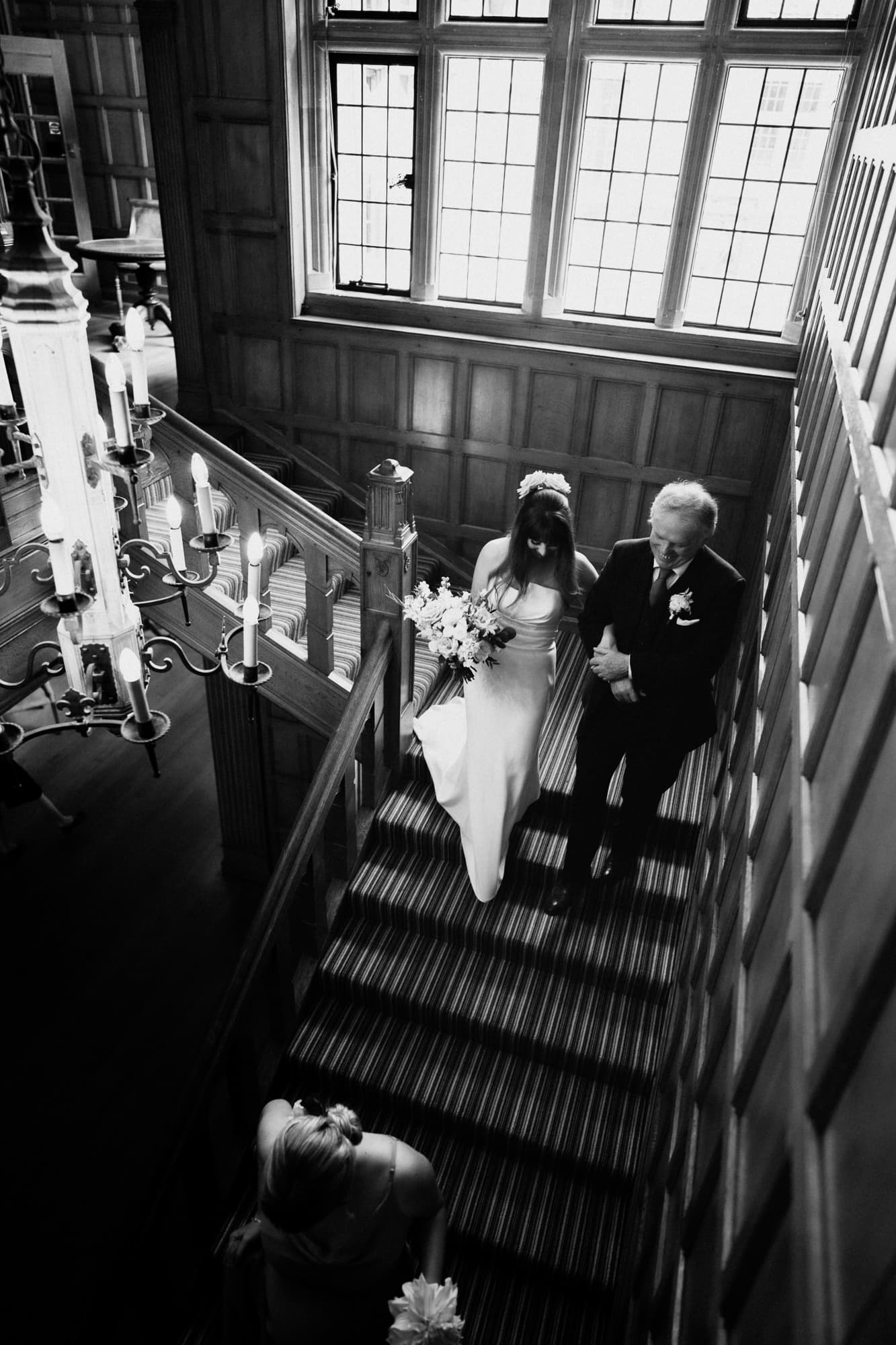 father and bride walking down stairs