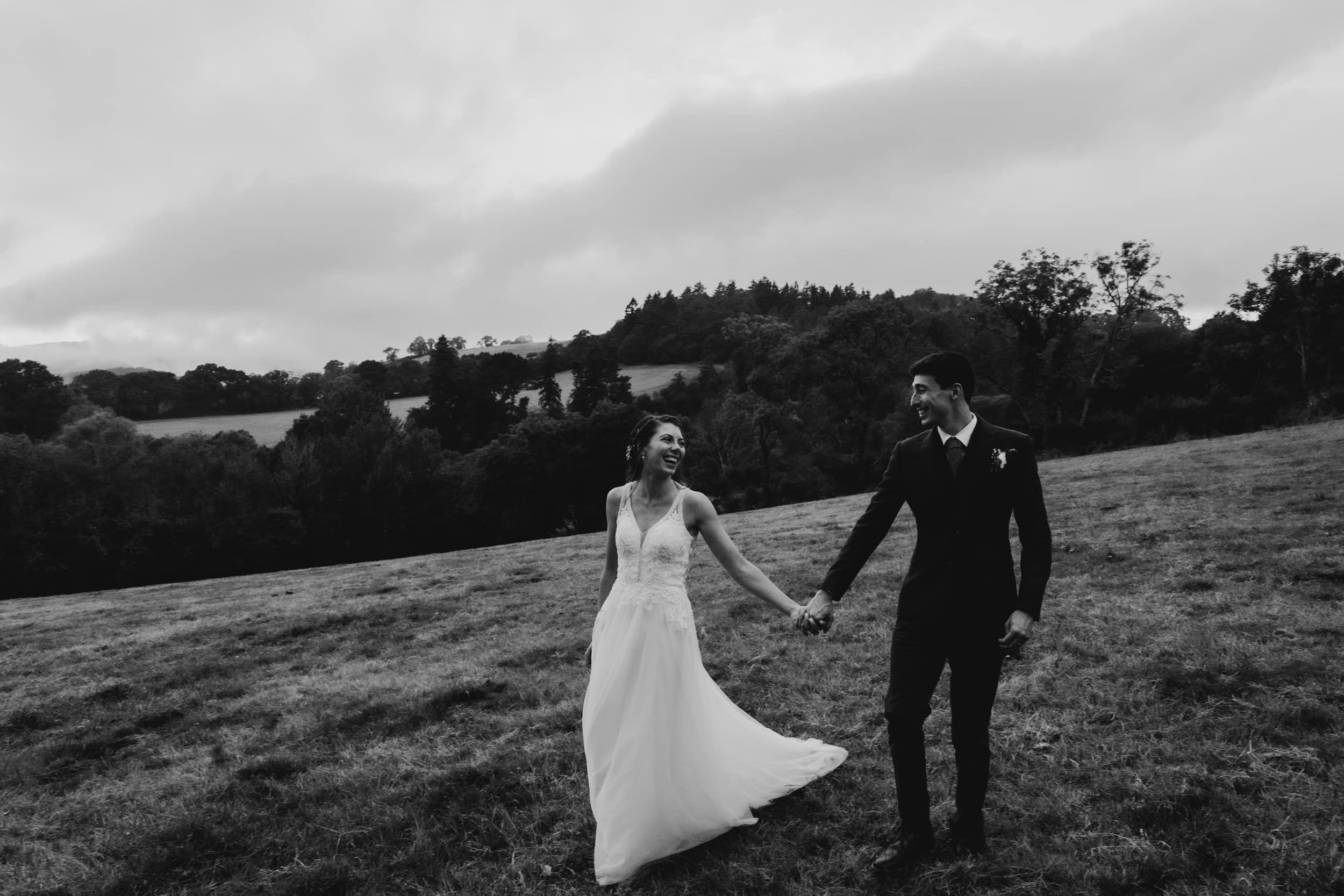 bride and groom walking through fields