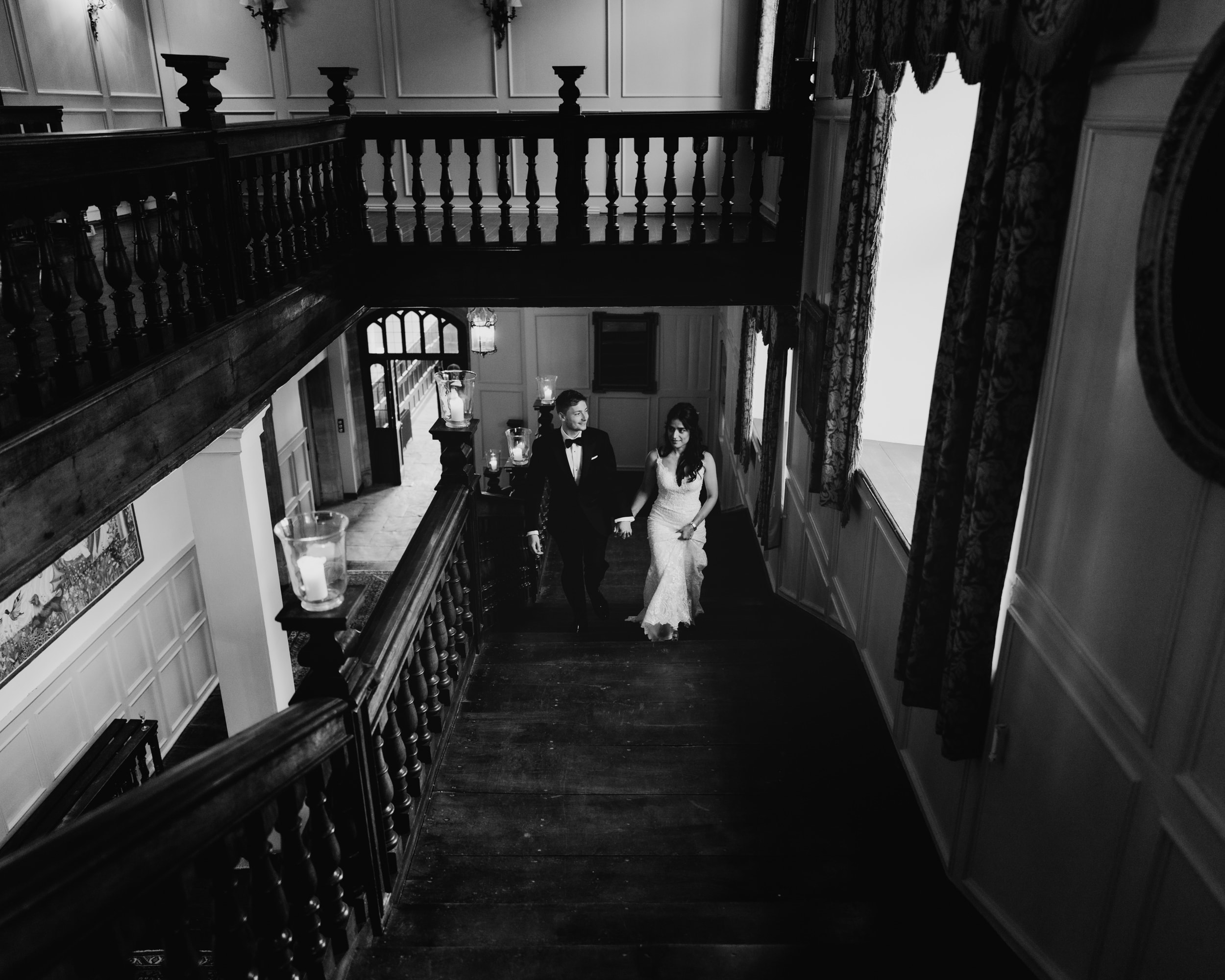newly wed couples walking up grand staircase in brympton house somerset